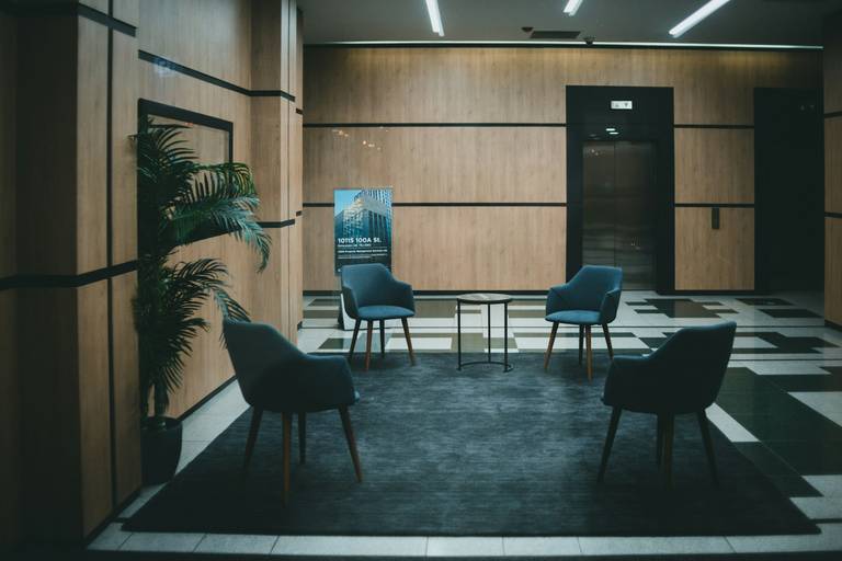 Bild einer Büroetage mit 4 leeren Stühlen.